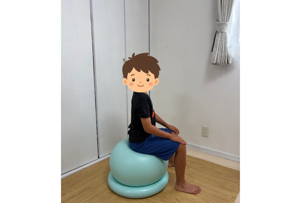 バランスボールに座って足裏が床につく様子